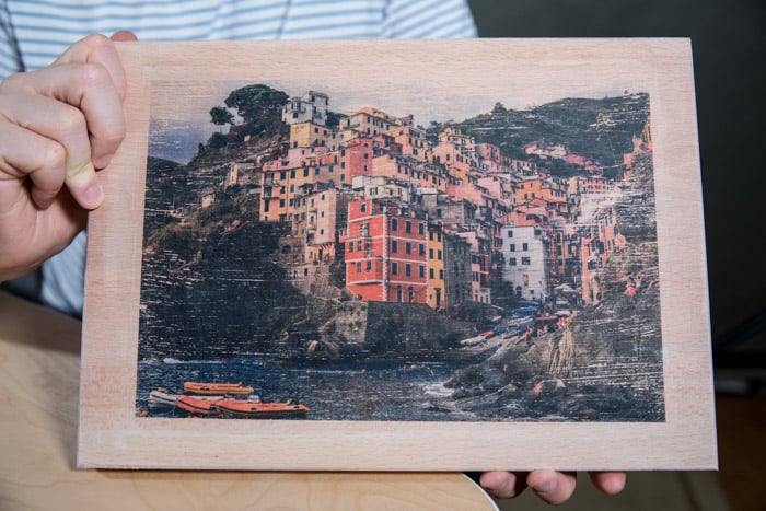 A man holding a photo printed on wood