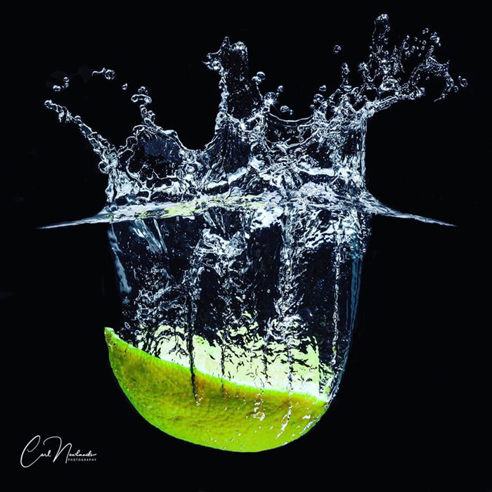 A halved lemon falling into water.