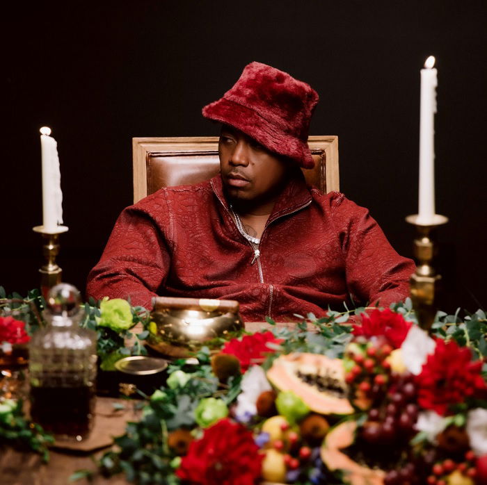 Portrait of Nas in silly hat sitting infront of table with lots of food on it